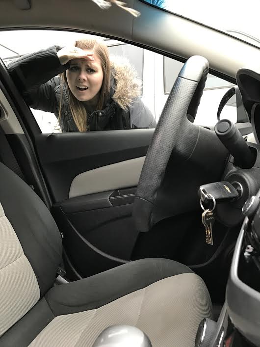 Person looking into locked car, keys inside.