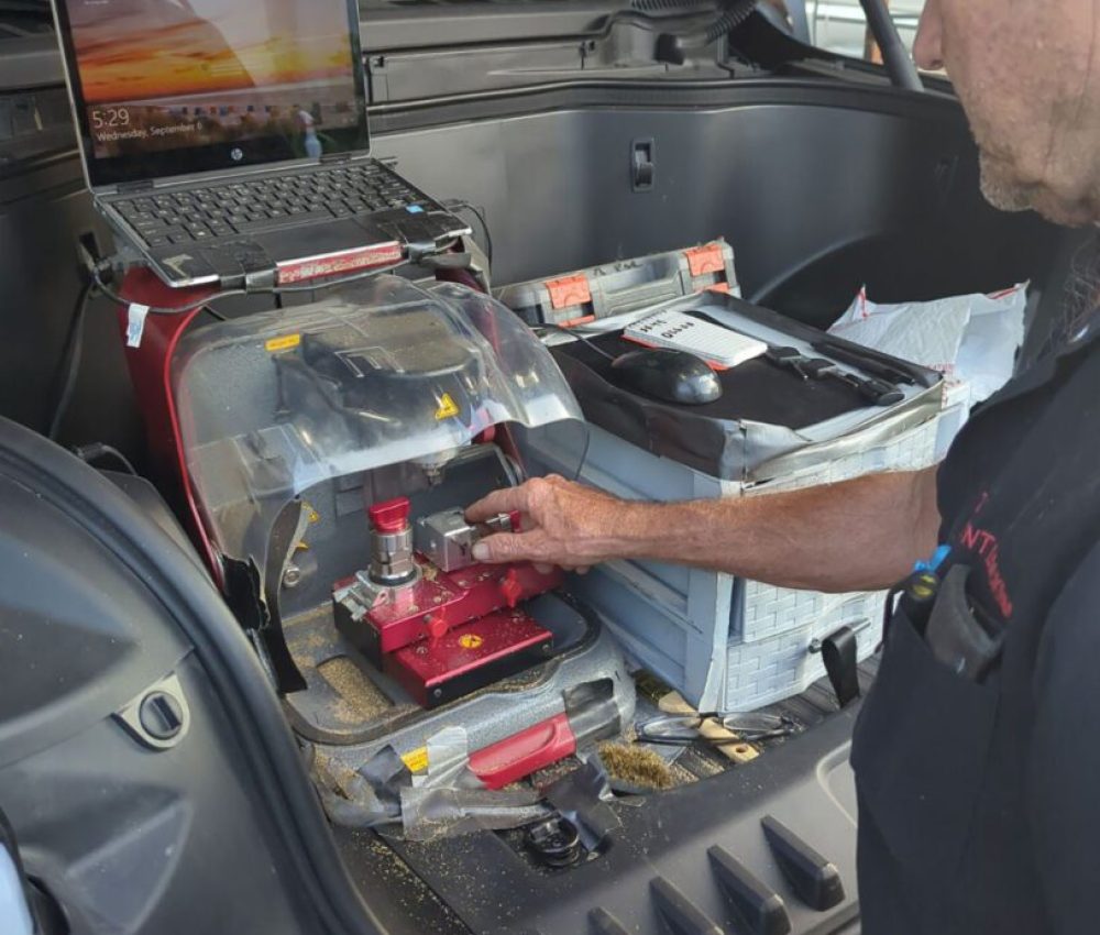 Locksmith performing professional automotive locksmith service using modern tools